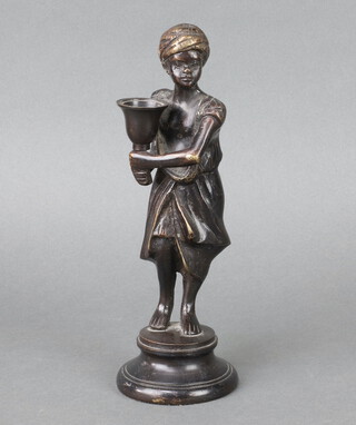 A bronze candlestick in the form of a standing figure on a circular base 24cm h x 8cm diam.