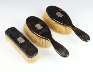 A pair of Edwardian tortoiseshell finished hairbrushes and matching clothes brush 