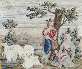An 18th/19th Century Berlin wool work and stumpwork picture of a standing shepherd by a tree with sheep 35cm x 42cm  
