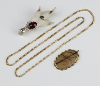 An amethyst pendant in a gilt metal mount hung on a gilt chain and a rabbits foot brooch 