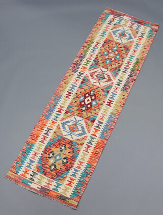 A faded green, white and brown ground Chobi Kilim runner with stylised diamonds to the centre 194cm x 59cm 