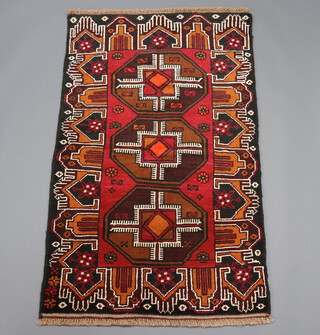 A brown, black and orange Belouche rug with 3 octagons to the centre 145cm x 88cm 