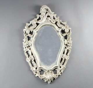 A shaped plate mirror contained in a carved wood and white painted plaster frame 62cm x 39cm 