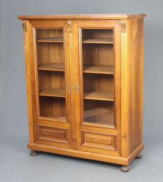 A 19th Century French walnut display cabinet, fitted shelves enclosed by glazed panelled doors, raised on bun feet 148cm h x 116cm w x 51cm d 