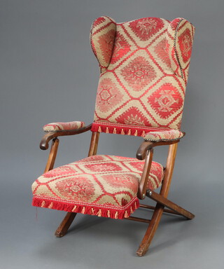 An Edwardian beech framed folding winged campaign chair upholstered in red and white material 106cm h x 64cm w x 56cm d (seat 26cm x 34cm) 
