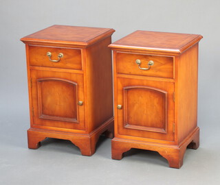 A pair of Georgian style walnut and crossbanded bedside cabinets fitted a drawer and raised on bracket feet 65cm x 41cm x 39cm 