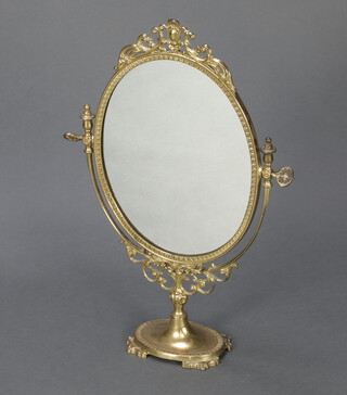 An oval plate dressing table mirror contained in a decorative gilt frame,  56cm x 39cm raised on an oval base