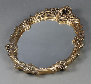 A shaped plate mirror contained in a decorative gilt frame 61cm x 44cm