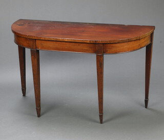 A 19th Century mahogany demi-lune table raised on square supports, spade feet 72cm h x 124cm w x 50cm d (scratches, water and contact marks, signs of old but treated worm to the back)