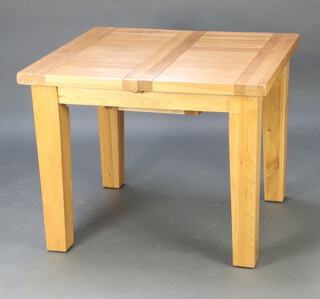 A square oak dining table with extra leaves raised on square supports 80cm x 100cm x 90cm 
