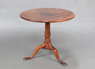 An 18th/19th Century circular yew snap top tea table, raised on a turned column and tripod base 58cm h x 66cm diam. 