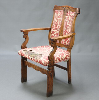 A Victorian Art Nouveau carved oak open arm chair, the shield shaped back and overstuffed seat raised on square supports 78cm h x 61cm w x 51cm d (seat 27cm x 30cm) 