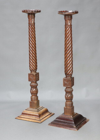 A pair of William IV circular turned mahogany bedpost torcheres raised on stepped square bases 133cm h x 37cm w x 35cm d 