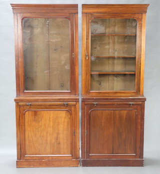 A pair of Victorian mahogany bookcases on cabinet with moulded cornice, the base fitted a brushing slide above cupboard enclosed by panelled doors, raised on a platform base 200cm h x 81cm x 28cm 