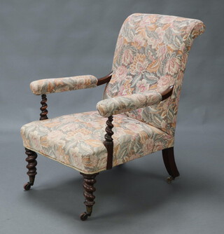A Victorian mahogany open armchair upholstered in pink floral material, raised on spiral turned supports 94cm h x 65cm w x 70cm d (seat 28cm x 38cm) 