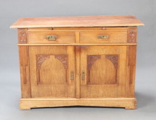 A 19th Century Art Nouveau Continental walnut cabinet fitted a brushing slide above 2 long drawers, the base enclosed by a pair of arched carved panelled doors, raised on a platform base 101cm h x 139cm w x 65cm d 
