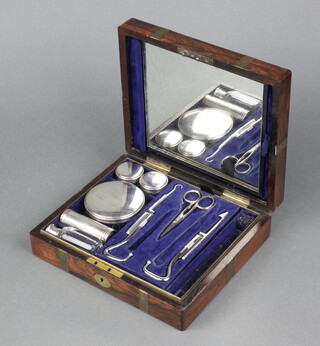 Mechie, a Victorian rosewood brass banded travelling vanity box with hinged lid, the interior fitted 2 polished steel folding boot hooks, shaving brush, circular cut glass perfume bottle, 3 cut glass jars with silver plated lids 6cm x 22cm x 19cm 