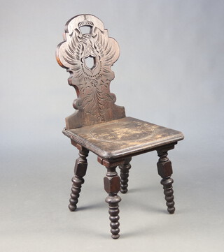 A Continental carved oak hall/spinning chair the back decorated an eagle, with solid seat, raised on bobbin turned supports 89cm h x 43cm w x 41cm d 