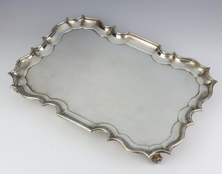 An Edwardian silver tray with Chippendale rim on scroll feet Sheffield 1906, 1660 grams 