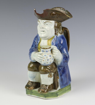 A 19th Century Toby jug in the form of a seated gentleman holding a mug of beer, on an octagonal base 24cm 