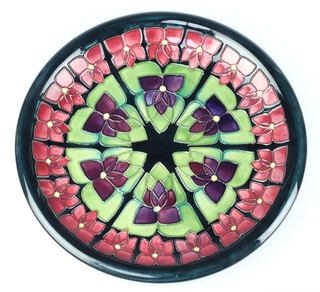 A modern Moorcroft shallow dish decorated with stylised flowers, impressed marks 26cm, boxed 