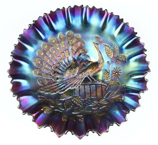 A purple Carnival glass dish decorated with peacocks 21cm 