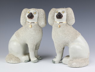 A pair of Victorian Staffordshire figures of Spaniels with mottled decoration 26cm 