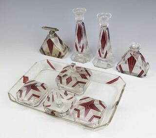 An Art Deco red flash glass dressing table set comprising tray, atomiser, scent bottle (no stopper), pair of candlesticks, 2 lidded boxes, a ring stand and a bo and cover 