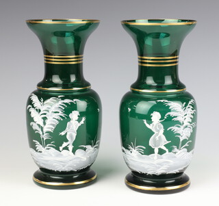 A pair of Mary Gregory style green glass baluster vases decorated with figures 24cm 