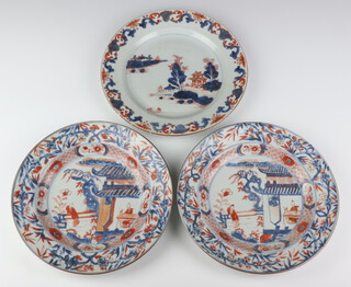 A pair of 18th Century Chinese Imari plates decorated with figures before pavilions enclosed in a floral border 22cm, together with a ditto with a landscape view and fishermen 22cm (a/f) 