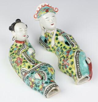 A pair of Chinese polychrome reclining figures of a lady and gentleman, the lady with pierced ears and metal hoop earrings, the robes decorated with flowers 18cm 