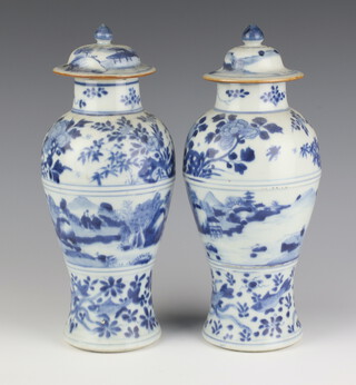 A pair of 19th Century Chinese blue and white oviform vases and covers decorated with a band of a landscape with figures, the bodies with flowers and fish amongst seaweed 28cm 