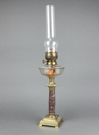 A Victorian cut glass oil lamp reservoir raised on a polished metal granite column with gilt metal embellishments, complete with chimney 66cm h x 12cm w x 12cm d 