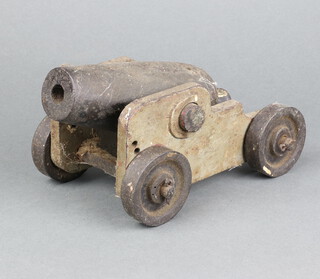An iron model of a canon raised on a steel carriage 24cm h x 10cm w 