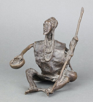 A Benin bronze figure of a seated gentleman with spear and bowl 15cm x 14cm x 12cm 