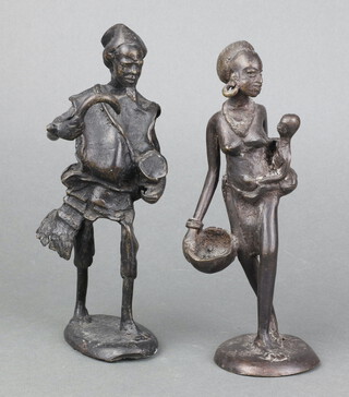 A Benin bronze figure of a standing lady with child and doll, raised on a circular oval base 21cm x 8cm together with 1 other of a standing farmer with scythe 21cm x 8cm x 5cm 