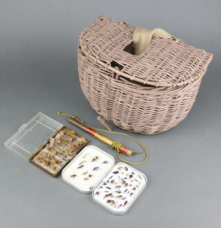 A Richard Wheatley fly box containing flies, a plastic fly box with flies and a fishing priest all contained in a basket ware creel 21cm h x 32cm w x 19cm d 