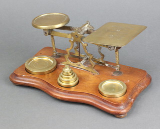 A pair of brass letter scales raised on a shaped mahogany base together with 7 weights 11cm h x 26cm w x 15cm d 