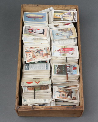 A collection of various cigarette cards, trade cards including Champion, Players, Wills etc contained in a small shallow box
