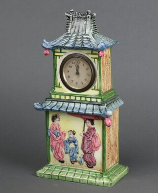 A 1930's bedroom timepiece with 5cm paper dial, Roman numerals, contained in a chinoiserie style pottery case in the form of a pagoda, the sides decorated fruits (1 fruit missing) 27cm h