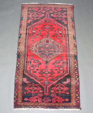 A black, red and green ground Iranian belouche rug with diamond to the centre 188cm x 91cm 