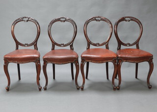 A set of 4 Victorian carved mahogany balloon back and serpentine shaped dining chairs with overstuffed seats upholstered in brown material, raised on cabriole supports 88cm h x 42cm w x 40cm d (seats 28cm x 27cm)   