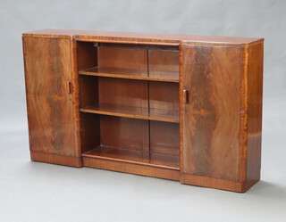 Brickers, an Art Deco inverted breakfront mahogany bookcase, the centre section fitted adjustable shelves enclosed by a pair of panelled doors, raised on a platform base 84cm h x 152cm w x 27cm d 
