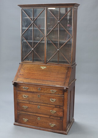 A 19th Century oak bureau bookcase the later associated top fitted shelves enclosed by astragal glazed doors, the fall front revealing a fitted interior above 4 long drawers 193cm h x 92cm w x 56cm d 