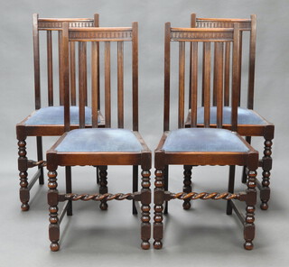 A set of 4 1930's oak stick and rail back dining chairs with upholstered drop in seats, raised on turned and block supports 