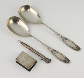 A silver match sleeve, 2 spoons and a propelling pencil 