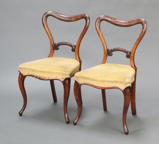 A pair of Victorian rosewood spoon back dining chairs with shaped mid rails and over stuffed seats, raised on cabriole supports 82cm h x 46cm w x 41cm d 