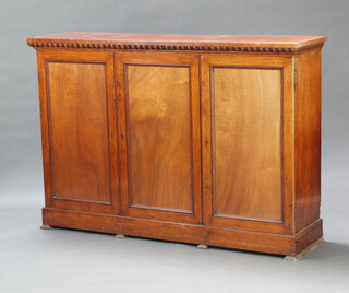 A Victorian bleached oak cabinet with shelved interior enclosed by triple panelled doors, raised on square tapered supports 109cm h x 160cm w x 43cm d 