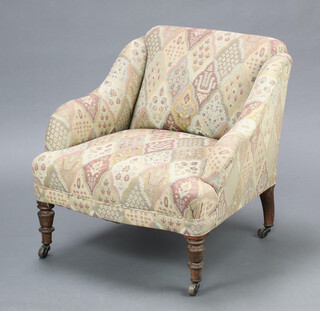 A Victorian armchair upholstered in tapestry material, on turned supports 63cm h x 65cm w x 61cm d 