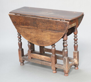 An 18th Century oak oval drop flap gateleg dining table fitted a frieze drawer, raised on turned and block supports 71cm h x 92cm w x 31cm d 